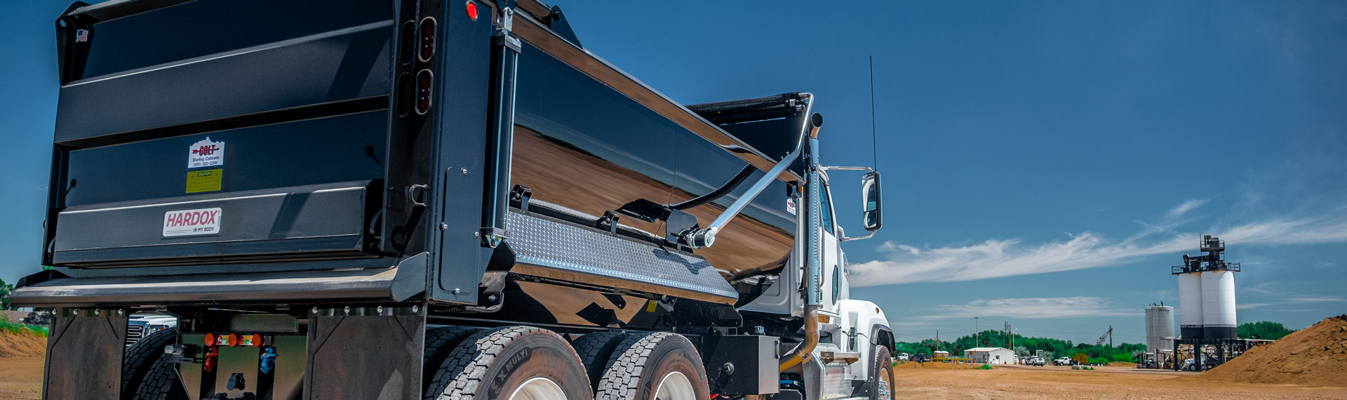 A truck with dump body bearing the Hardox In My Body logo.