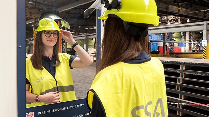 Woman checking safety equipment in mirror